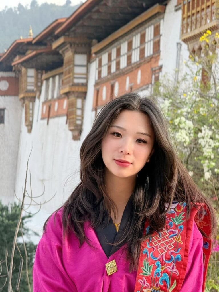 Ugyen Choden of 1Solution in front of a dzong